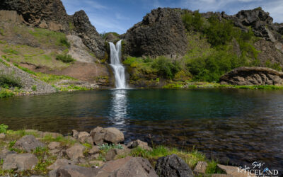 Waterfall in Lava cliffs with lake in front called Gjáin