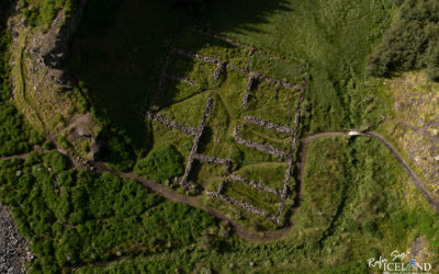 Old sheep round up made out of stones, seen from air in summertime with lot of green gras all around..