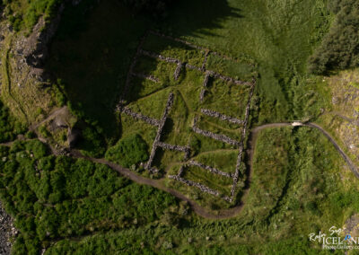 Old sheep round up made out of stones, seen from air in summertime with lot of green gras all around..