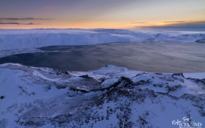 Lake seen over mountains in winter with snow on top in the morning twilight