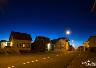 A scenic view of a street in Iceland, adorned with quaint houses that reflect the country's distinctive architectural style in the twilight.