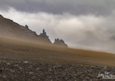 Sandstorm on a rugged hill, its silhouette contrasting against the rocky terrain in Iceland.