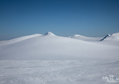 Glacier snowy mountain peeks in Iceland, surrounded by stunning cold winter landscapes under a blue sky.