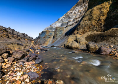 A flowing stream traverses a rocky landscape in Iceland, capturing the essence of the island's dramatic natural environment.