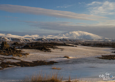 A beautiful snowy terrain with a mountain, showcasing an Icelandic volcano in the background, evoking a peaceful atmosphere.