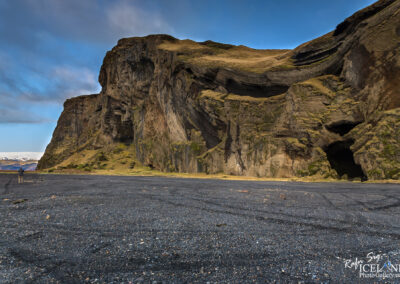 A striking large rock formation rises dramatically, its rugged surface contrasting with the serene environment around it.