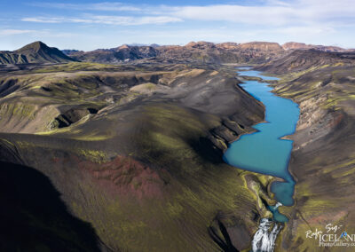 A picturesque blue lake set within Iceland's dramatic mountain range, capturing the essence of the breathtaking environment.