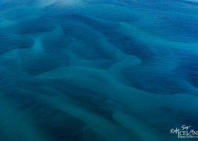 A vast expanse of water reflecting the sky, surrounded by distant landforms and a serene atmosphere.