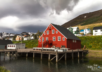 A vivid red building is prominently featured in the Icelandic landscape, adding a splash of color to the picturesque scenery.