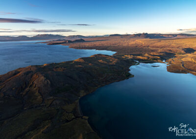 A vast expanse of water reflecting the sky, surrounded by distant land forms.