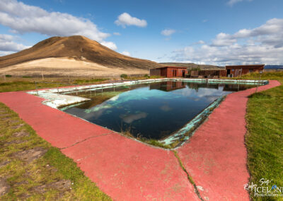 A picturesque pool area featuring a red and white fence, offering a charming and colorful setting for relaxation.