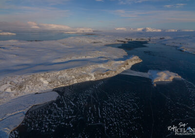 Bird's-eye view of a Lake, featuring sparkling waters and a serene horizon under bright sunlight.